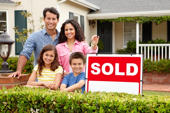 latino-family-in-front-of-home-with-sold-sign