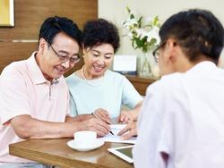 Asian couple signing contract with agent